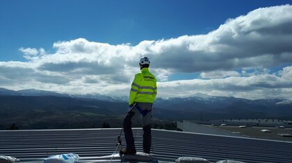 Trabajador sobre un tejado asegurado con una línea de vida horizontal